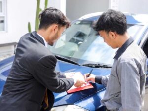dos jóvenes firmando la contratación de una póliza de seguro de auto 